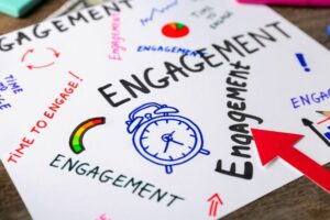 Sheet of paper with written words ENGAGEMENT on table, closeup improve social media engagement