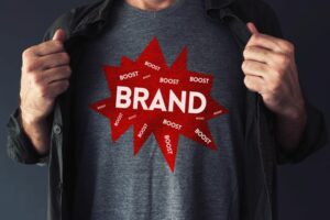 Brand boosting concept with handsome guy showing t-shirt with text mock up improve social media
