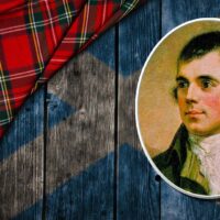 a portrait of Robert Burns overlaid upon weathered wood planks painted with the Scottish flag and a tartan.